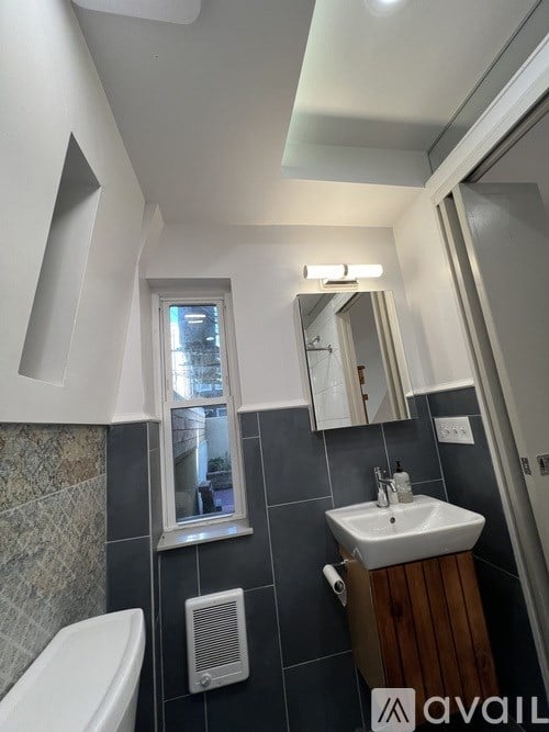 A bathroom with a white sink and a window.