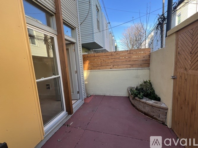 A patio area with a wooden fence and a small garden.