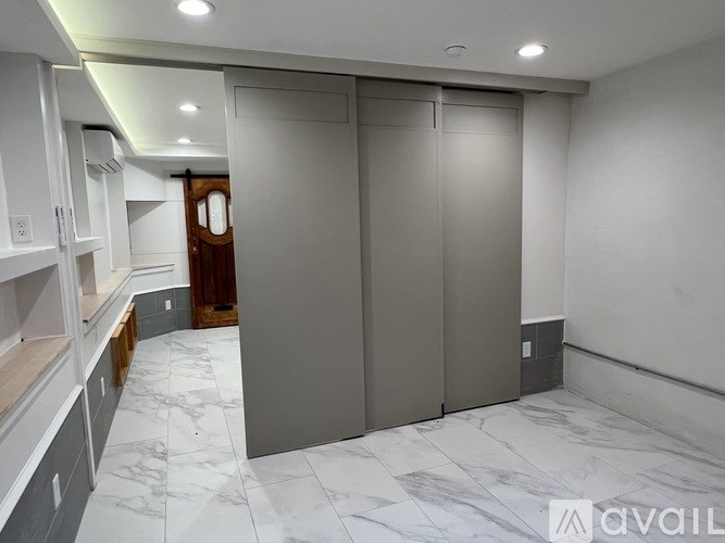 A kitchen with marble flooring and a wooden door.