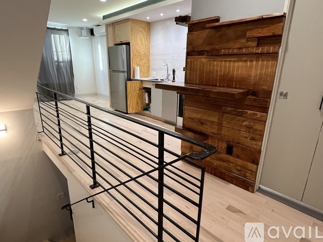 A modern kitchen with a wooden staircase.