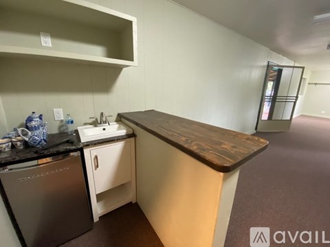 A kitchen area with a stainless steel dishwasher and a wooden counter.