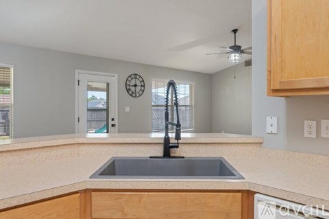 A kitchen with a sink and a clock on the wall.