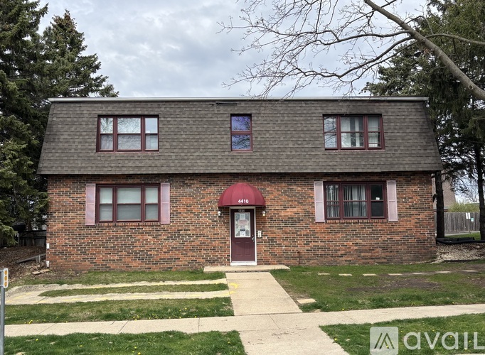 A brick house with a red awning and a sign that says 416.