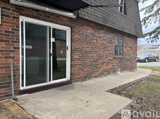 A brick building with a glass door and a small window.