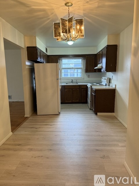 A kitchen with wooden floors and a chandelier.