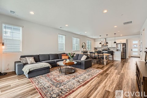 A living room with a grey sofa, a coffee table, and a rug in the middle.