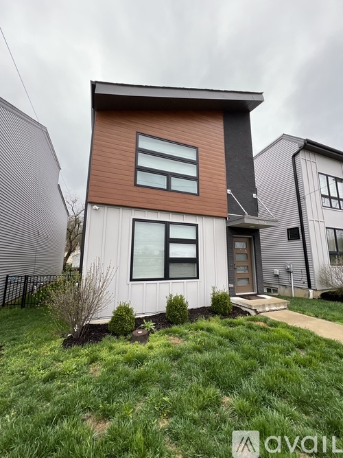 A modern house with a brown and white exterior is for sale.
