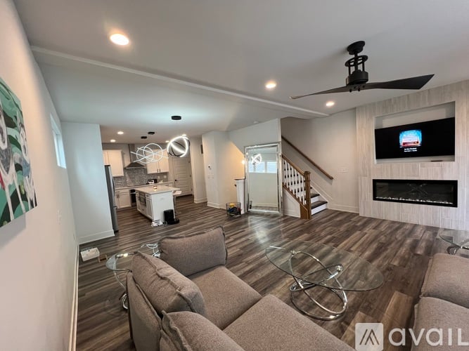 A living room with a grey couch and a television on the wall.