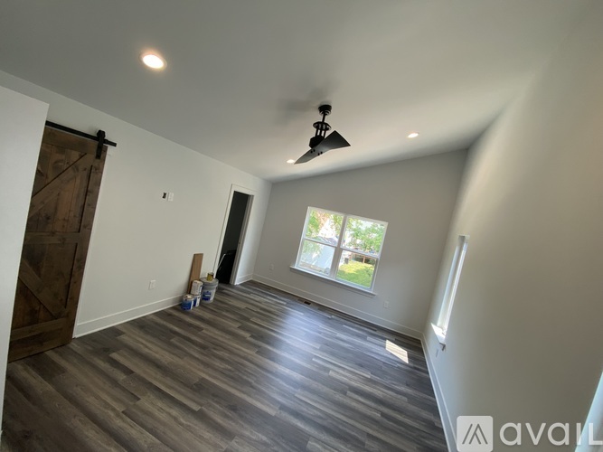 A room with wooden flooring and a ceiling fan.