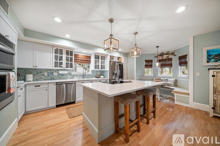 A kitchen with a large island and wooden floors.