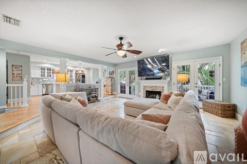 A living room with a long couch and a ceiling fan.