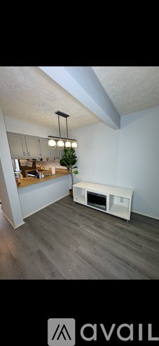 A modern living room with a white sofa and a wooden floor.
