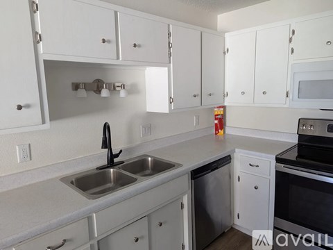 A kitchen with white cabinets and a stainless steel dishwasher.