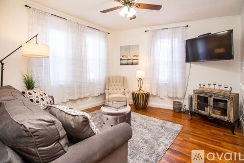 A living room with a grey couch and a white chair.