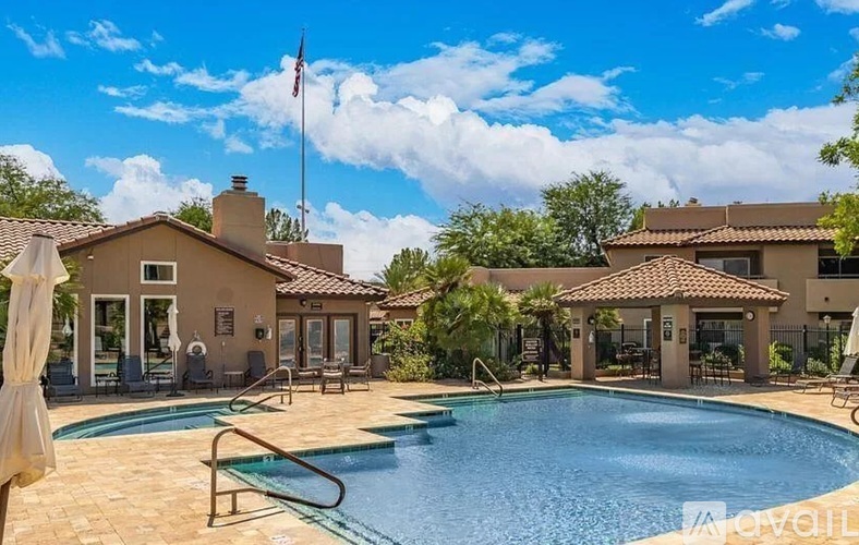 A pool in a backyard with a house and a flag in the background.