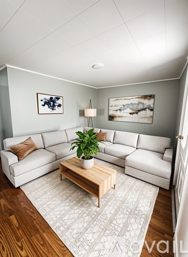 A living room with a white couch and a wooden coffee table.