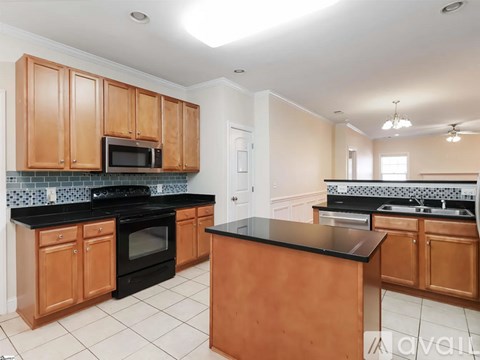 A kitchen with wooden cabinets and black countertops.