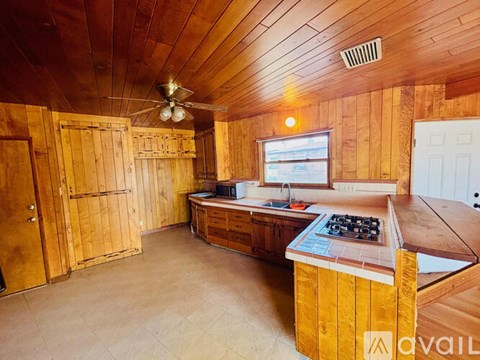 A wooden cabin with a kitchen area and a window.