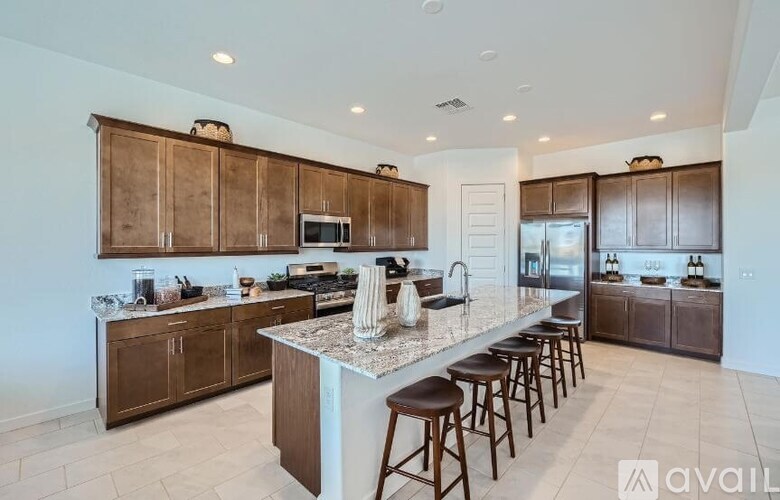 A kitchen with brown cabinets and a marble island.