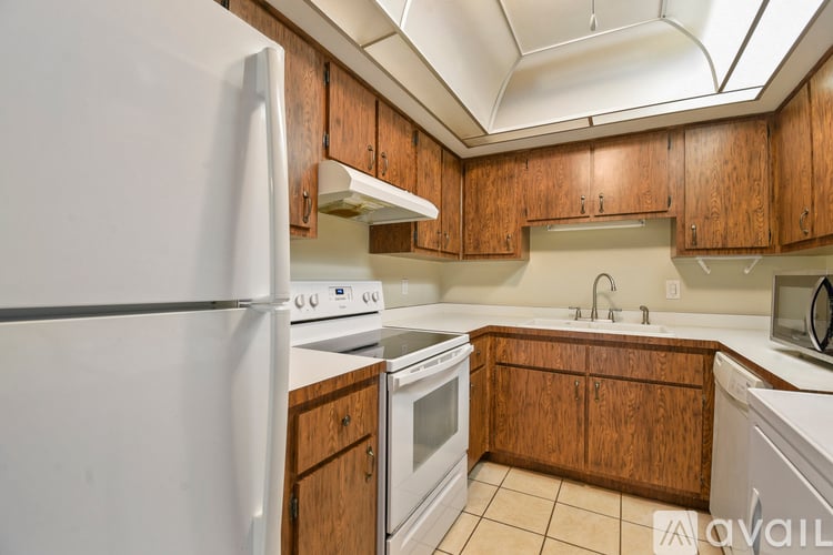 A kitchen with wooden cabinets and white appliances.