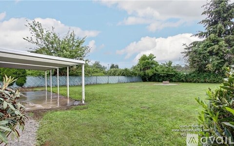 A backyard with a white pergola and a baseball diamond.