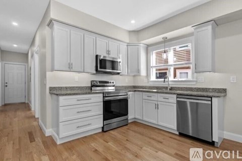 A kitchen with white cabinets and a granite countertop.