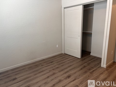 A room with a white door and a wooden floor.
