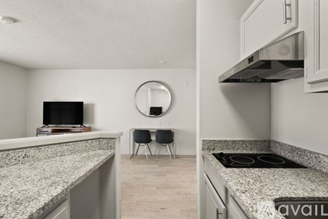 A kitchen with granite countertops and a stove top oven.