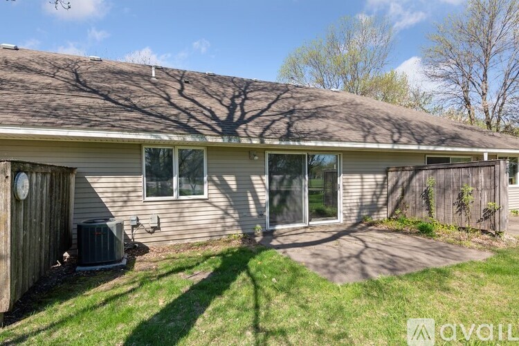 A house with a brown roof and a tree shadow on the ground.