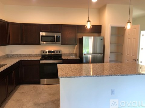 A kitchen with brown cabinets and a granite countertop.
