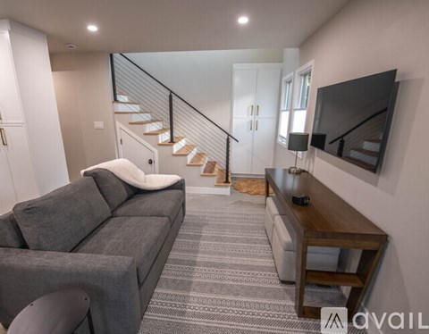 A living room with a grey couch and a wooden coffee table.