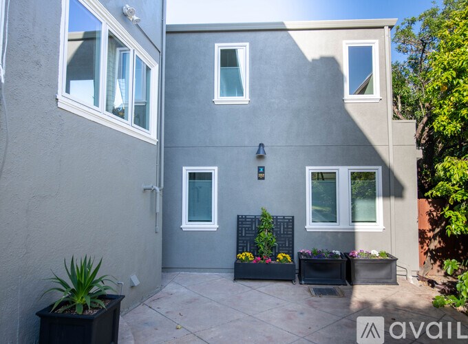 A grey house with a small garden in front.