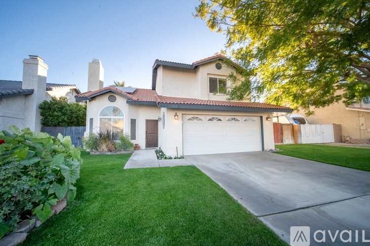 A house with a garage and a driveway is available for sale.
