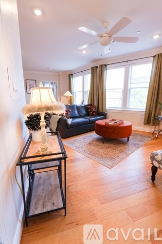 A living room with a black coffee table and a red ottoman.