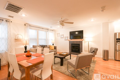 A modern living room with a fireplace and a dining table set for four.