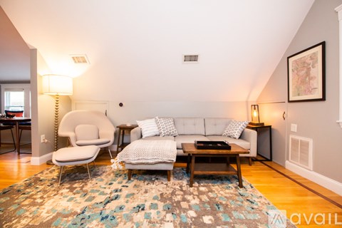 A living room with a white couch and a grey chair.