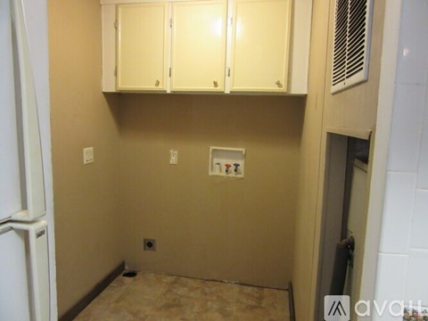A kitchen with white cabinets and a beige wall.