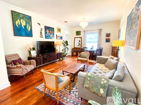 A living room with a grey couch and a wooden floor.