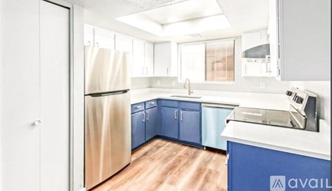 A kitchen with blue cabinets and a white fridge.