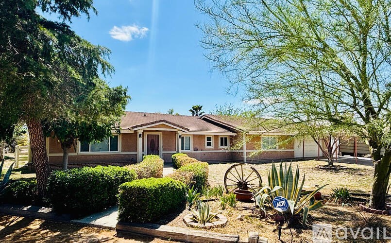 A house with a brown roof and a sign that says "For Sale" in front of it.