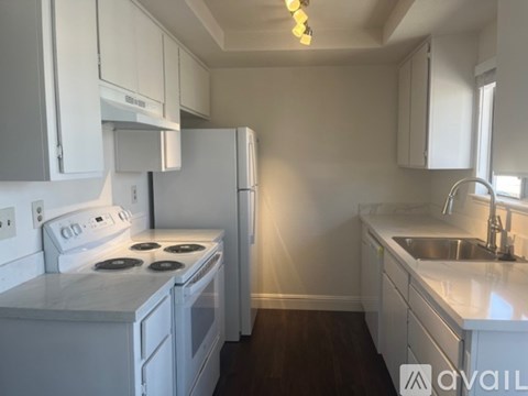 A kitchen with white appliances and cabinets.