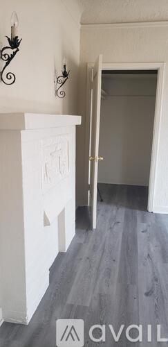 A white fireplace with a black iron decoration above it.