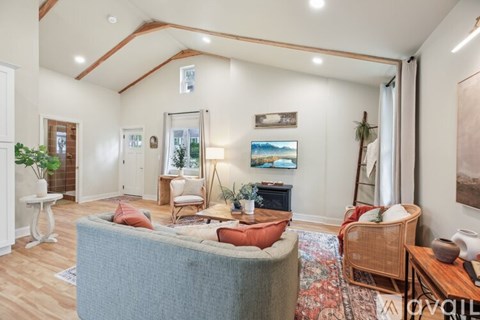 A living room with a grey couch and a wooden floor.