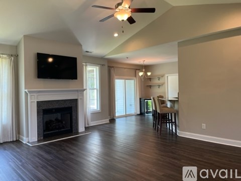 A living room with a fireplace and a television mounted above it.