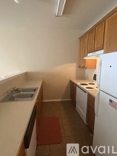 A kitchen with a white fridge and a stove top oven.