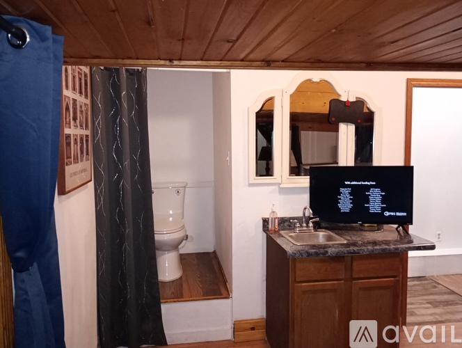 A bathroom with a toilet, sink, and mirror.