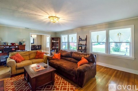 A living room with a brown leather couch and a coffee table.