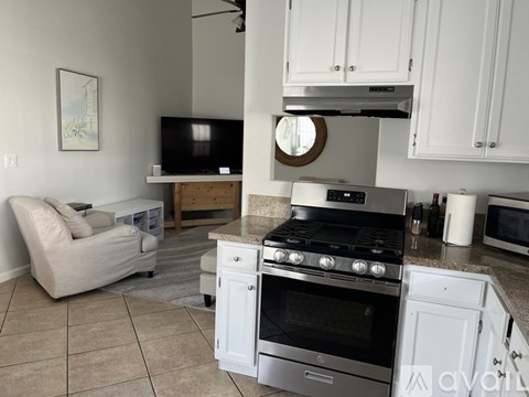 A kitchen with a white oven and white cabinets.