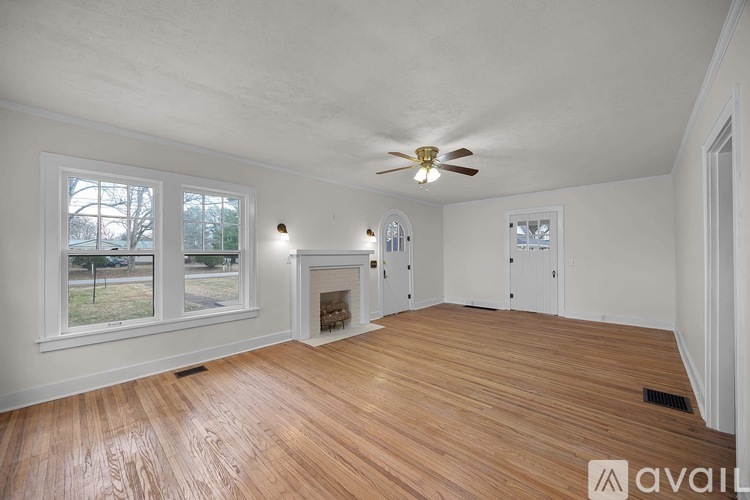 A room with wooden floors and a ceiling fan.