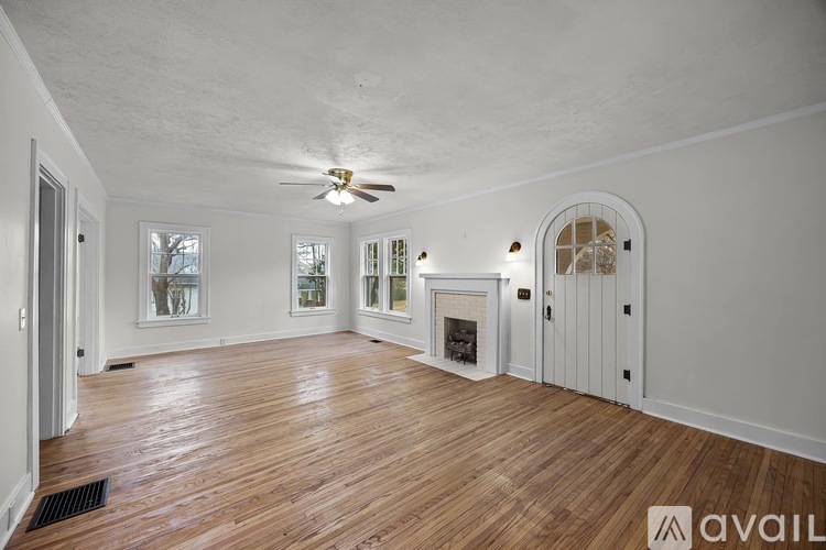 A spacious room with wood flooring and a fireplace.